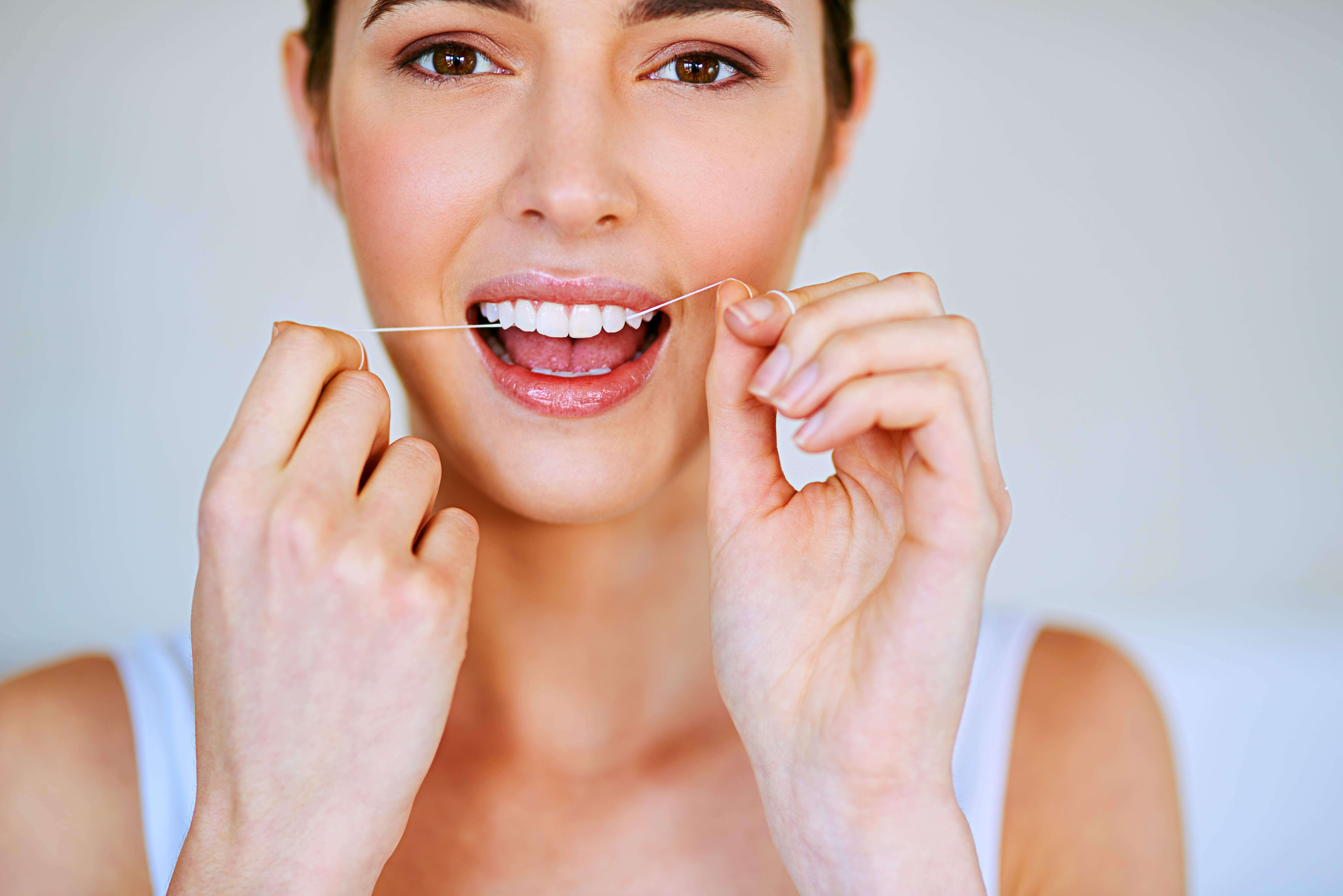 Mujer usando hilo dental